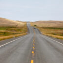 photo is of a long road ahead, with the yellow line in the middle of the frame.