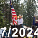 young rodeo girl on a horse carrying American flag