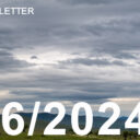 photo of grey skies on the horizon over a green landscape.